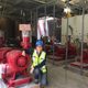 Martha Larson, the Manager of Campus Energy & Sustainability and project manager of the Utility Master Plan next to one of the new pumps in the EES.