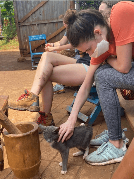 Female student petting a cat in front of mortar and pestle