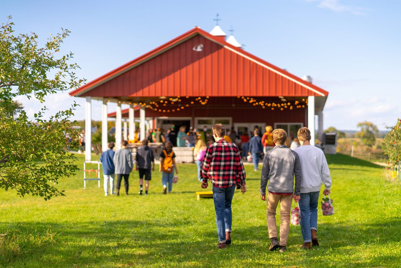 students walk toward a barn at the apple orchard