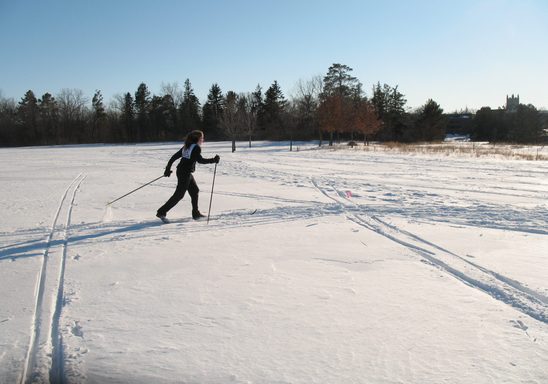 A woman skiing on a snowy field.