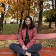 Suhani Thandi seated on a red bench in the trees