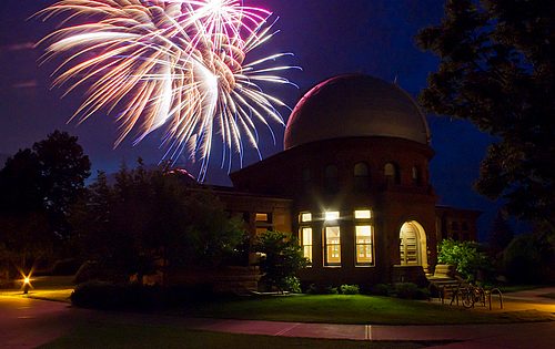 Fireworks appearing in the night sky behind Goodsell Observatory