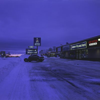 The sun begins to rise over a strip mall blanketed in snow