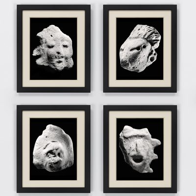 Four black and white images of rocks shaped like faces in black frames arranged to form a rectangle.