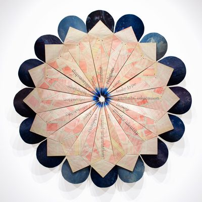 Large artistic paper sculpture shaped like a circular flower with dark blue edges and a light pink center constructed from paper with a faint pattern and words printed on it.