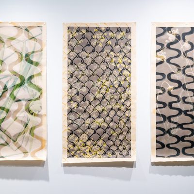 Three vertically hanging scrolls with chain link patterns superimposed over images.