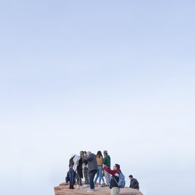 Portrait of blue sky with tourists clamoring for photo of view in lower third