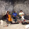 three musicians in a room with chalk-covered walls