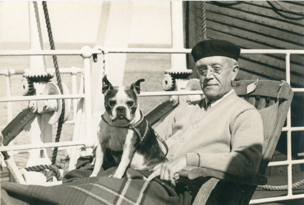 Beret-wearing Blayney on ship with dog