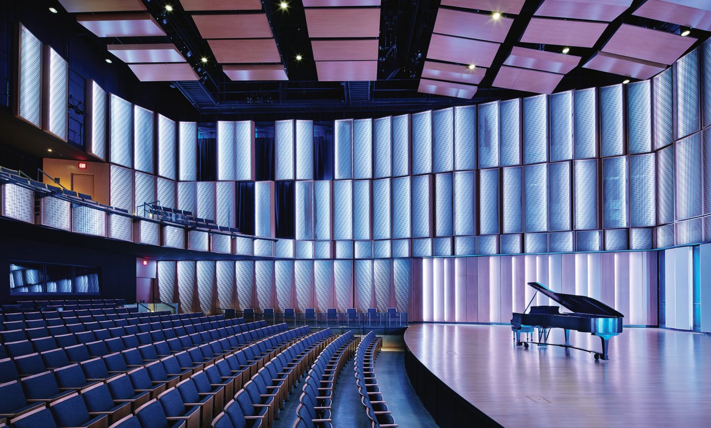 A grand piano on stage in an empty performance hall