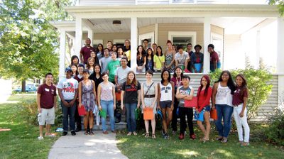 A large group of students in front of a campus house