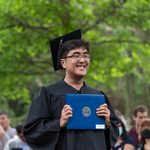 graduate posing with their diploma