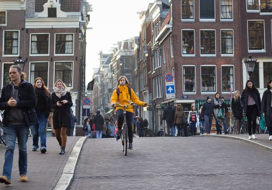 A woman on a bike in a busy Amsterdam street
