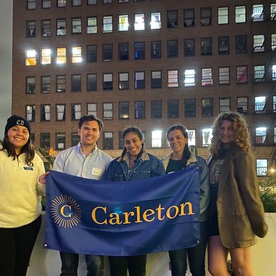 Young Alumni posing with the Carleton banner on a rooftop in downtown Los Angeles.