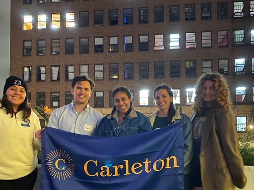 Young Alumni posing with the Carleton banner on a rooftop in downtown Los Angeles.