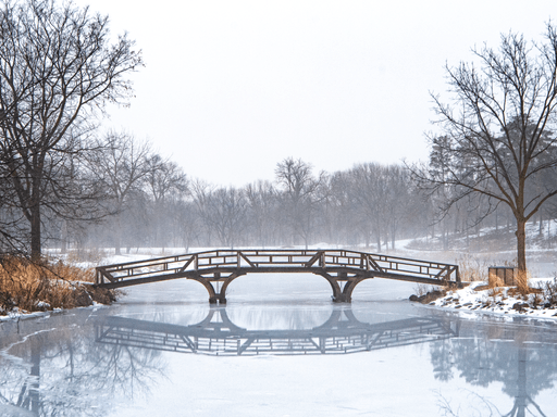 A frozen lake and a bridge running over the lake.
