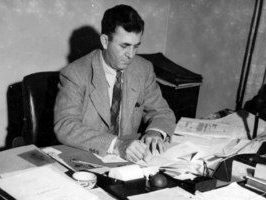 Black and White photo of Laurence McKinley Gould seated at a desk with books