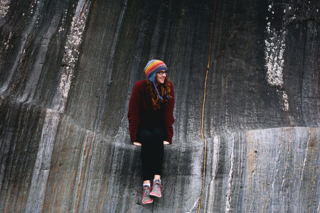 Emily Ross sits on a huge striped rock