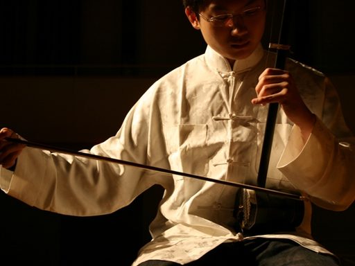 Photo of a young man playing a traditional Chinese stringed instrument