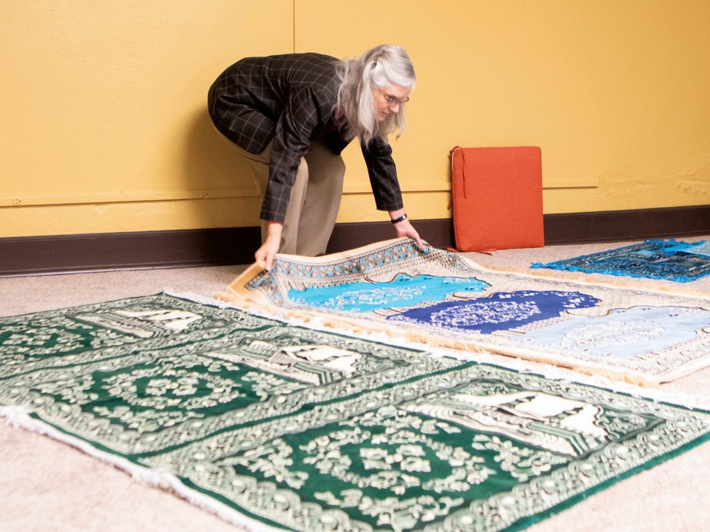 Carolyn Fure-Slocum laying out prayer rugs