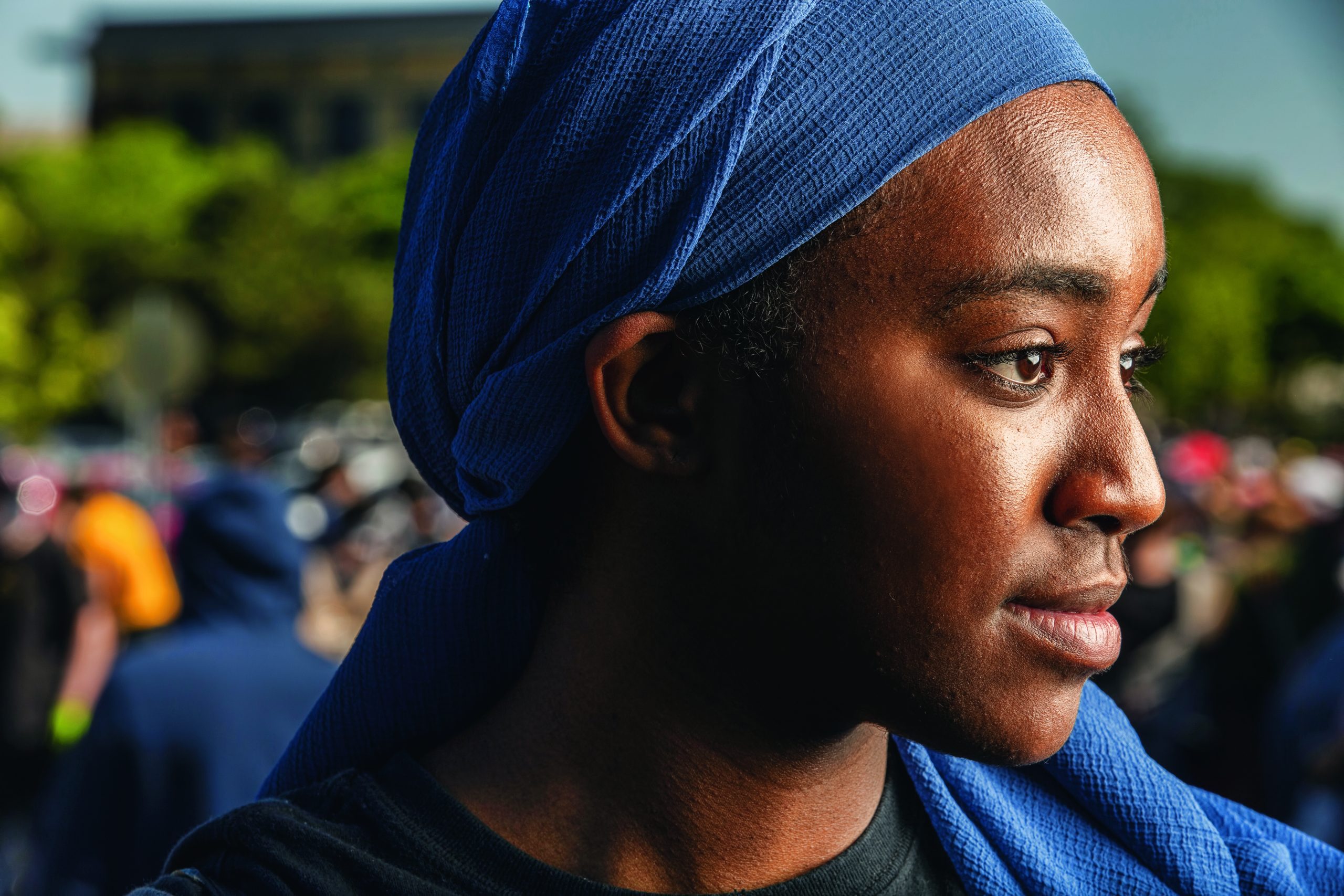 A Black woman wears a pale blue scarf over her head