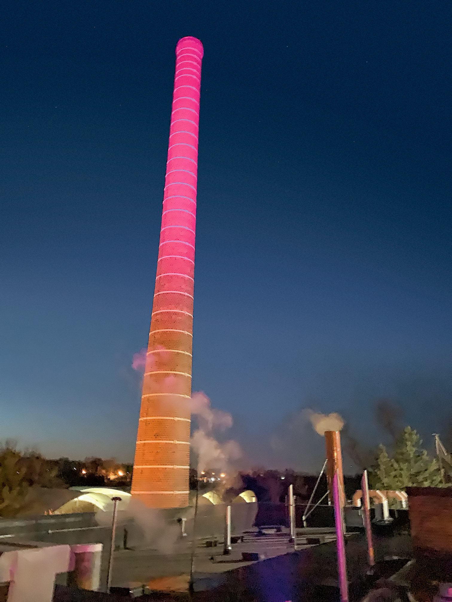 Carleton's smokestack lit up in celebration of the End of Steam on campus
