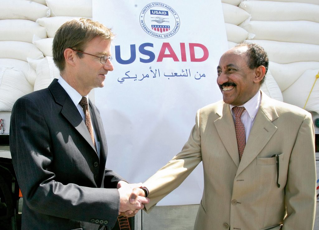 American Ambassador to Jordan, David Hale shakes hands with Abdelwahab Jeme, the World Food Program representative