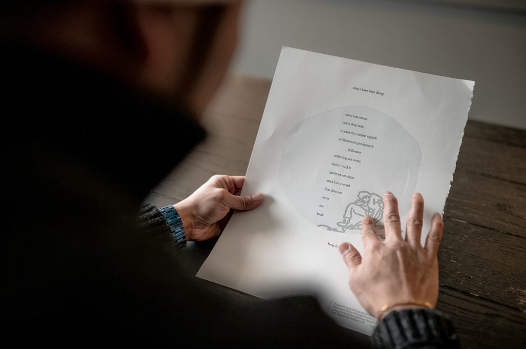 Fong Lee holds a poem he wrote