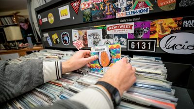 A person flips through albums in the KRLX record library
