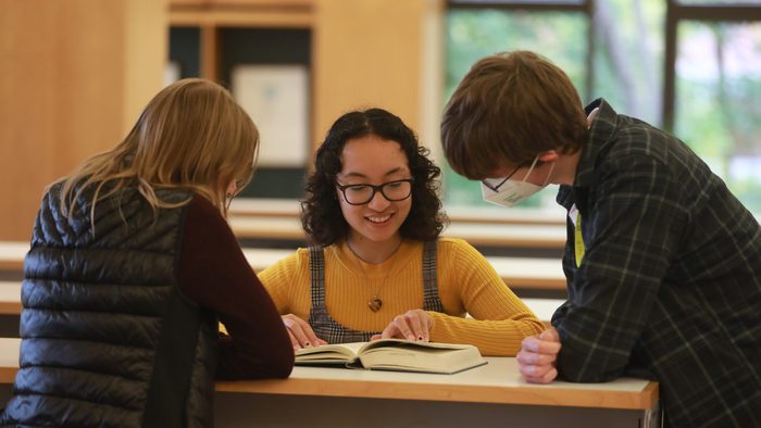 students looking at a book together