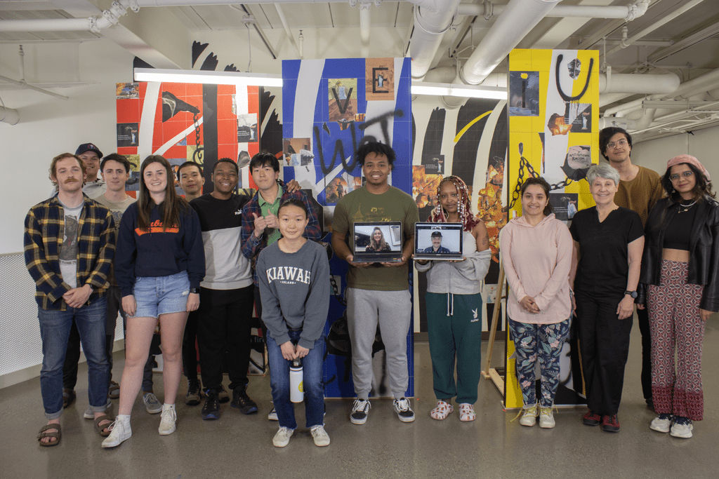 students pose for a group photo with their projects