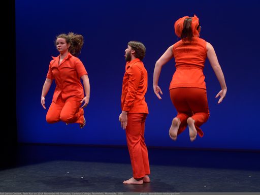 Two dancers jumping and one standing, all wearing red