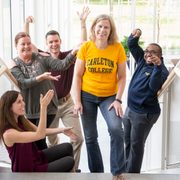 Karen Schilling stands on a stairway surrounded by four Carleton staff members