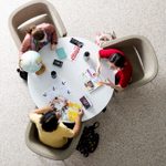 Three students seated at a round table, viewed from overhead