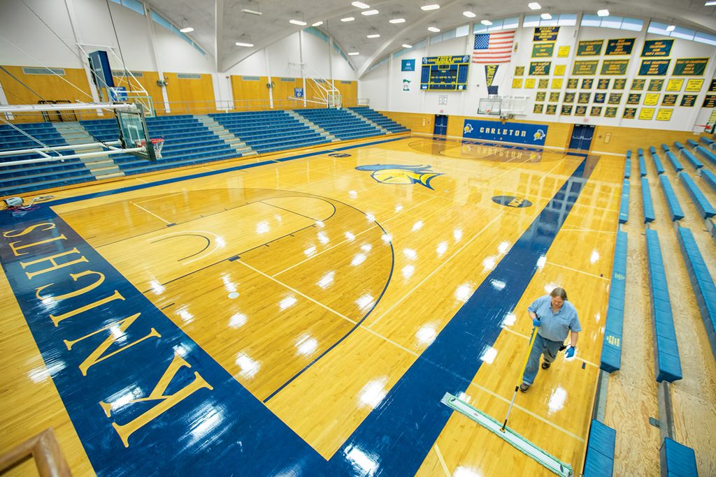a man sweeps a basketball court