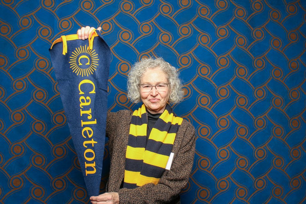 woman holding a Carleton pennant