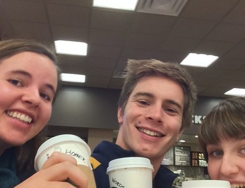 three people holding Starbucks coffee cups