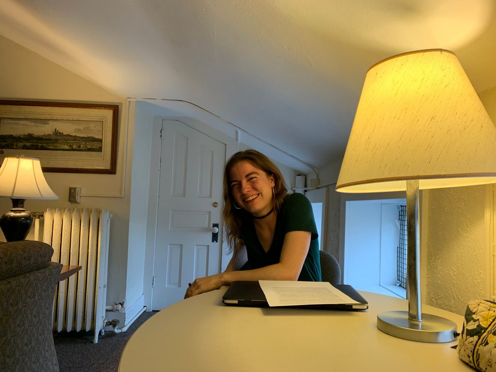 A woman reads beside a lamp